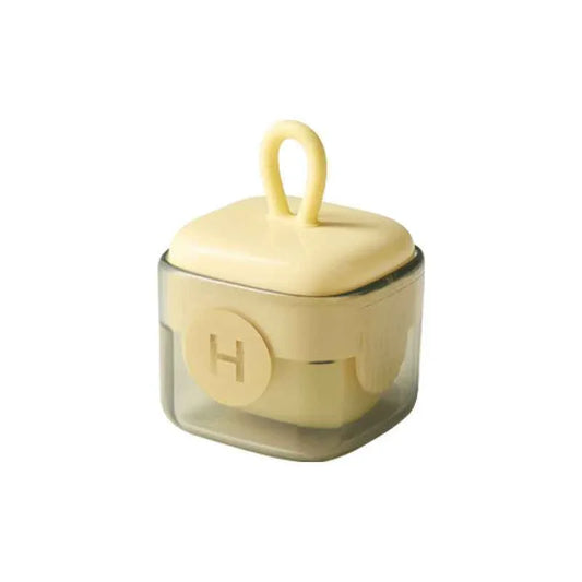 Small transparent square container with pale yellow lid and handle, labeled with letter H