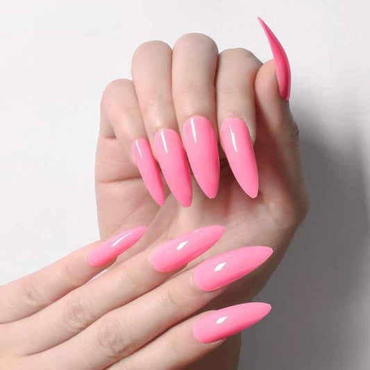 Glossy bright pink stiletto acrylic nails on hands with white background