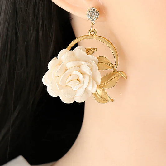 Elegant gold hoop earring with white fabric flower and crystal stud on female ear